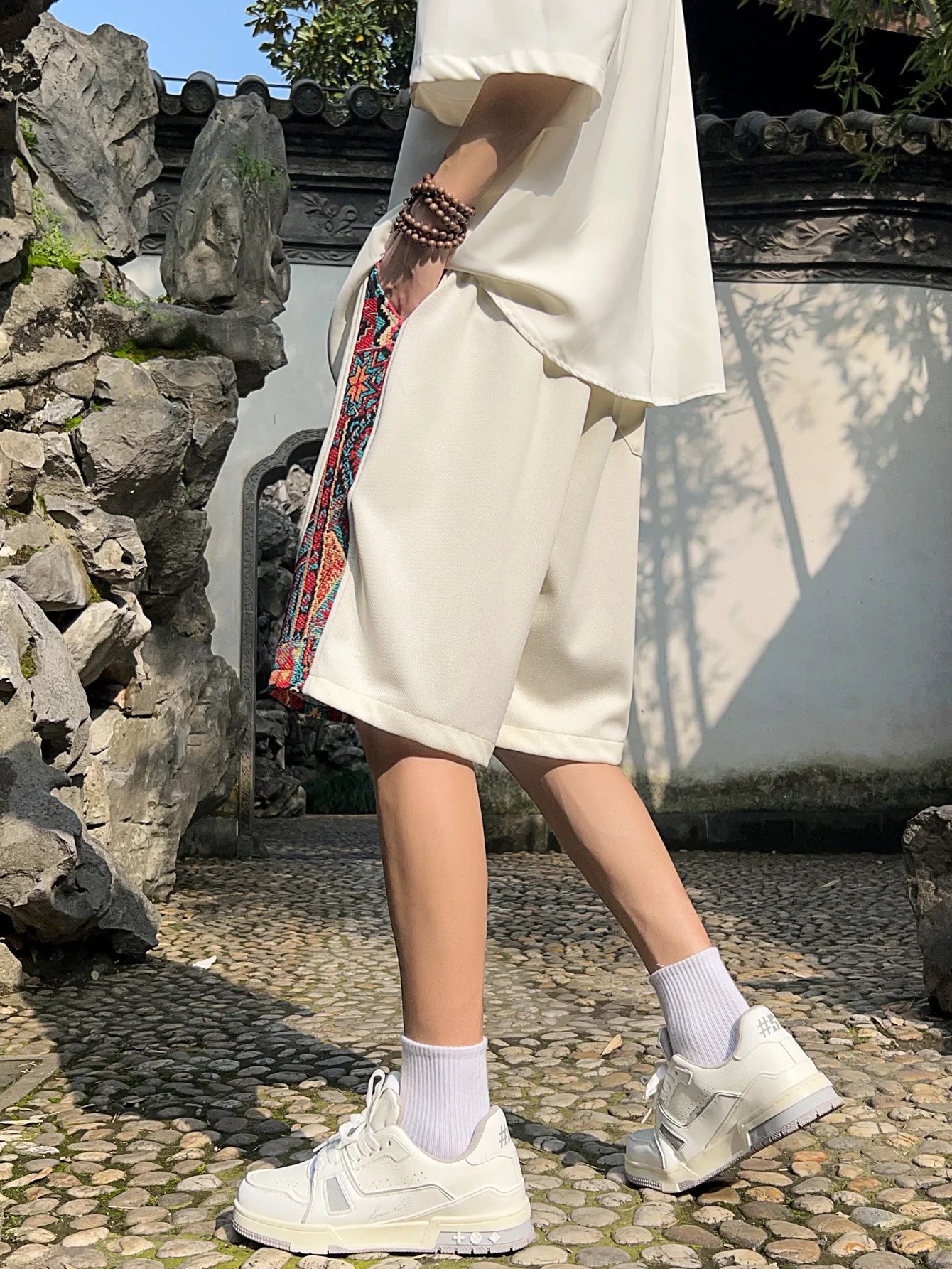 Side view of white ethnic patchwork shorts with colorful panel and relaxed fit