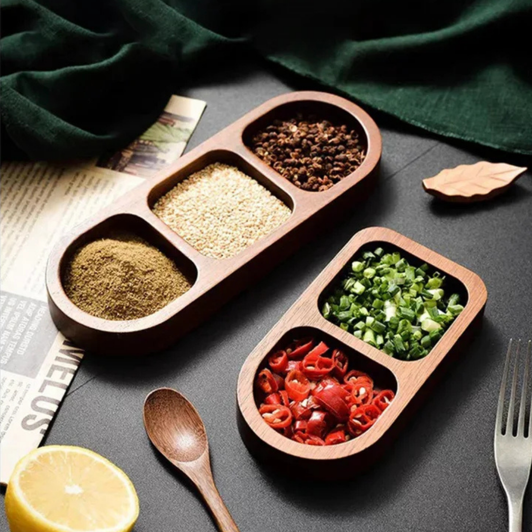 Solid wood condiment trays filled with ground spices, sesame, chili, and green onions on a dark table setting