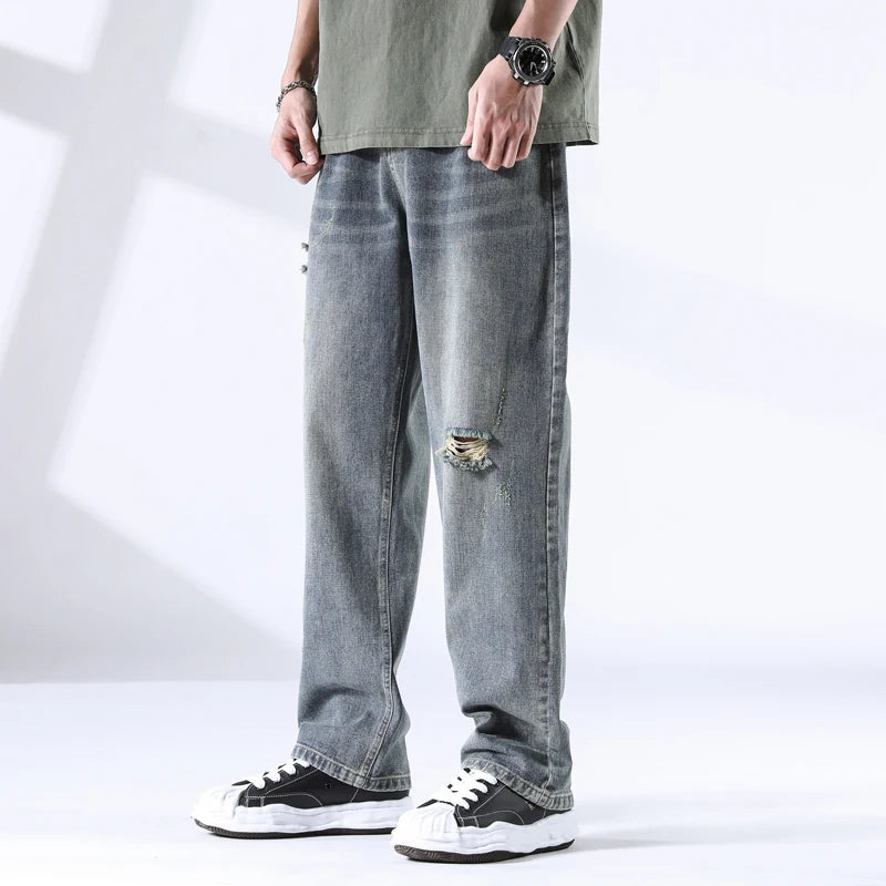 Stone blue straight leg jeans with ripped knee, light fade wash, front view