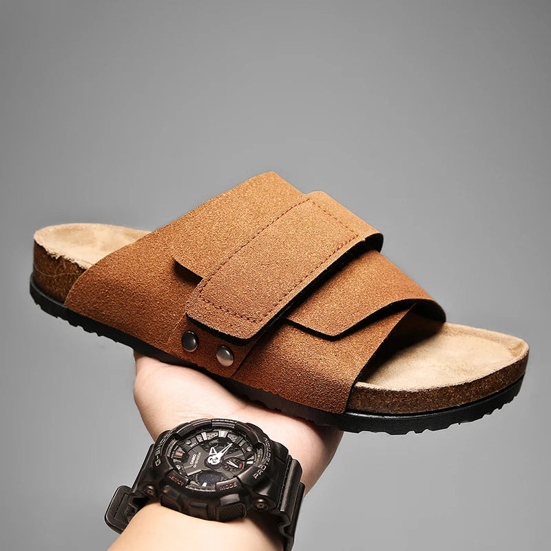 Tan brown suede leather men's sandals with adjustable straps, held in hand