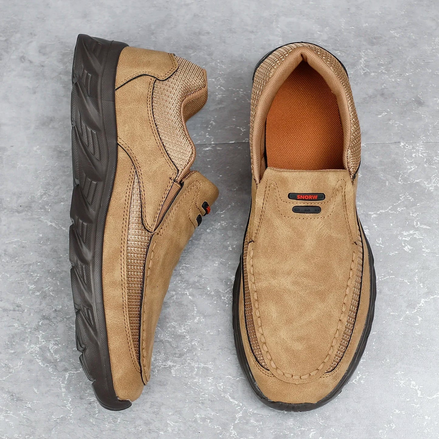 Tan leather loafers on the ground, showcasing soft upper and rugged sole