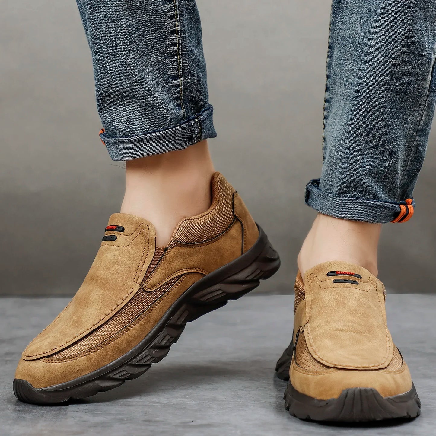 Tan suede leather casual shoes styled with cuffed jeans, front walking angle