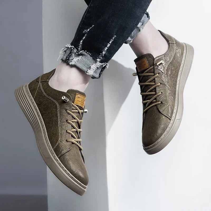 Taupe brown leather sneakers worn with black denim, casual indoor view