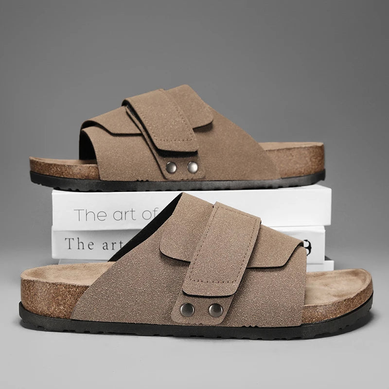 Taupe suede strap sandals for men stacked on white books, soft cork insole visible