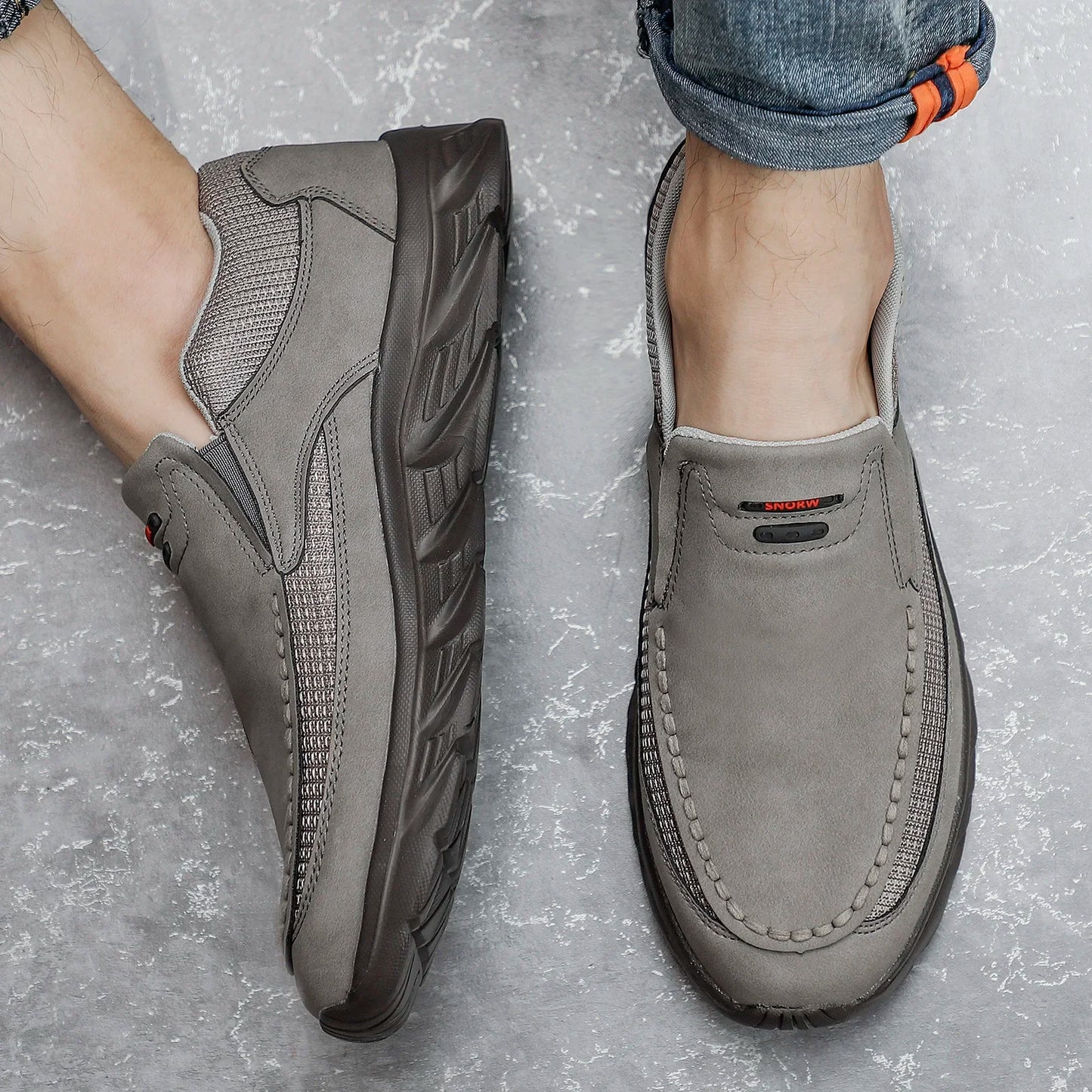 Top and side view of grey slip-on leather shoes for men on concrete floor