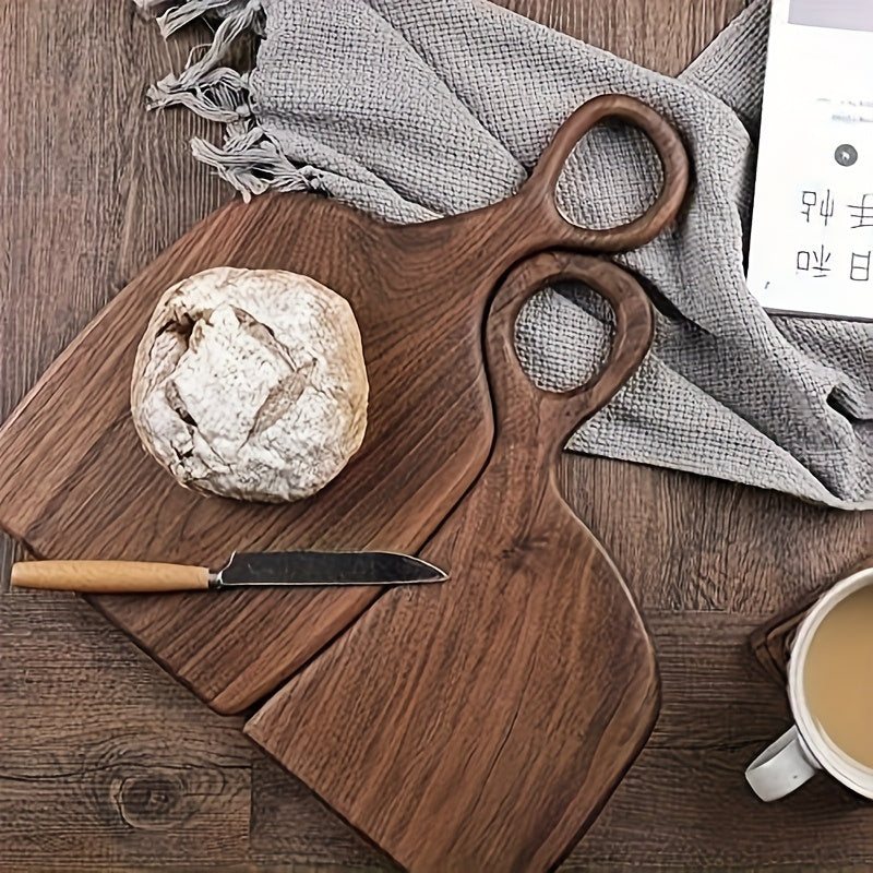 Top view of walnut cutting boards with bread and knife on wooden table