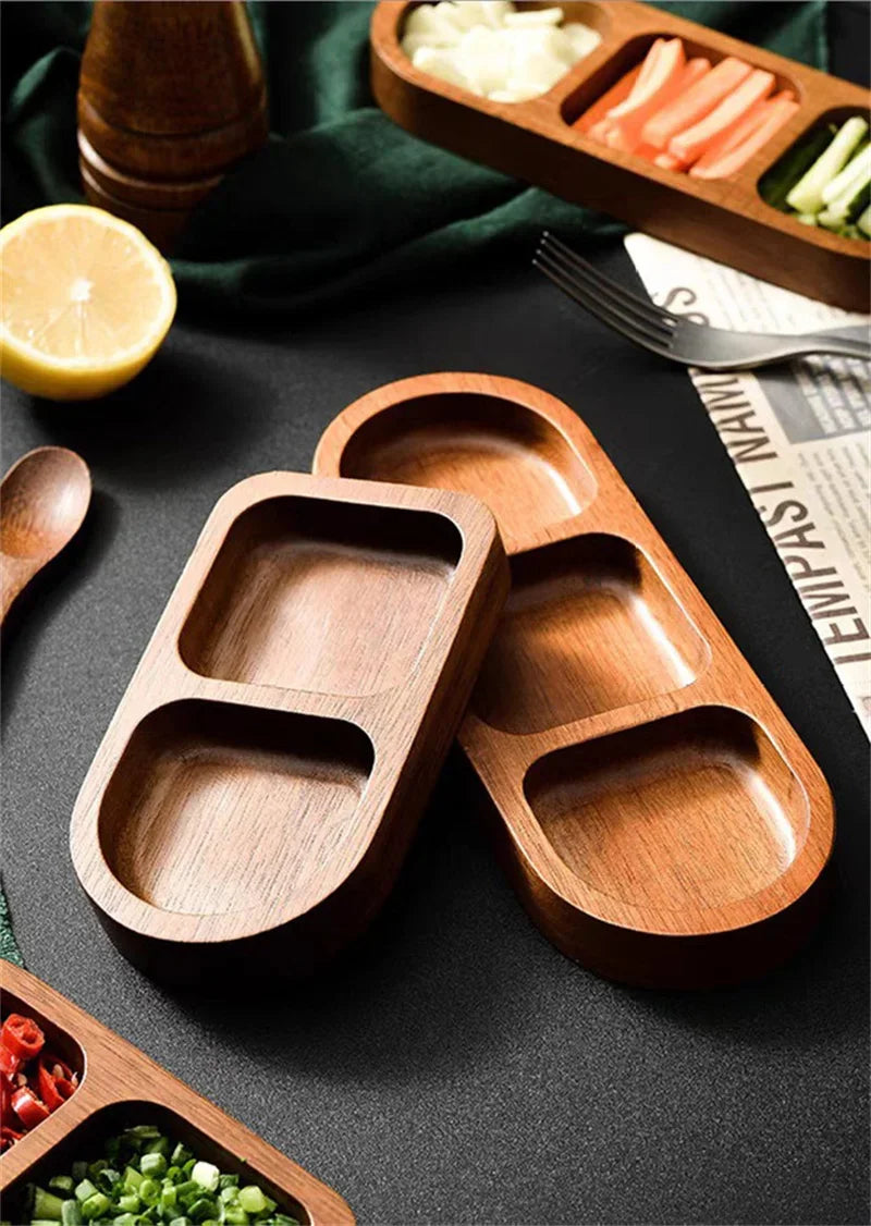 Two empty solid wood condiment trays with smooth rounded compartments, shown on a dark tabletop setting