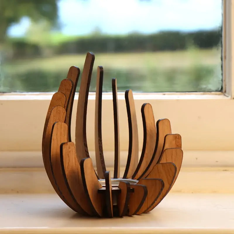 Unlit lotus-style wooden candle holder placed on window sill