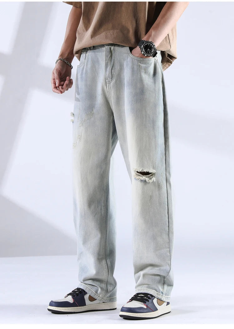 Washed black ripped denim jeans with light fade and casual styling shown from front
