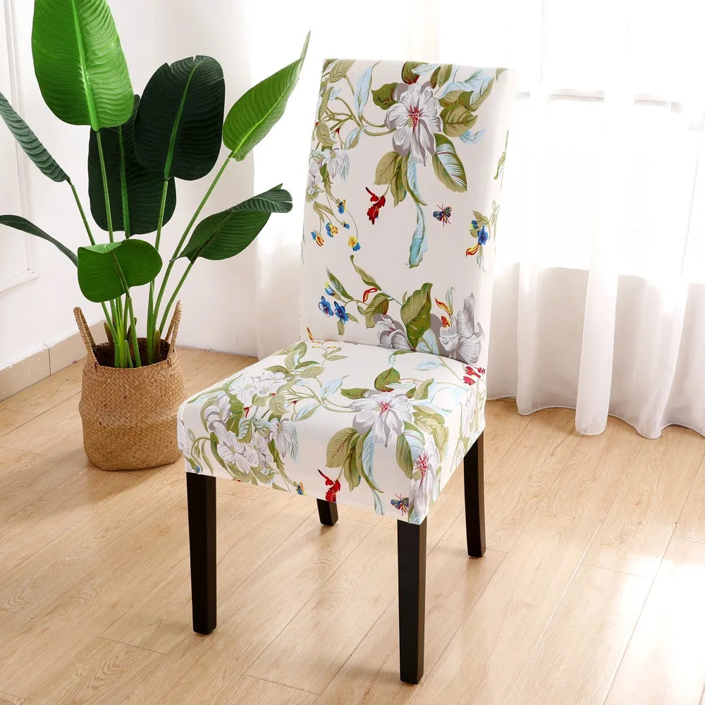 White stretch chair cover with large floral prints and flying hummingbirds in a sunny room