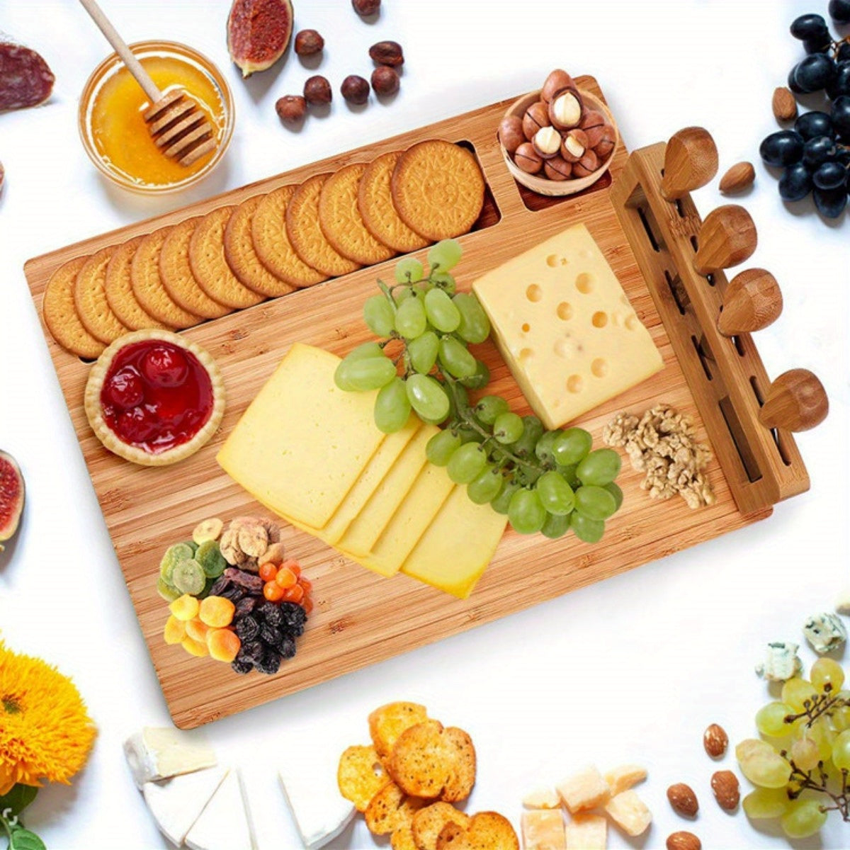 Wooden charcuterie tray with cheese slices, grapes, nuts, and serving knives