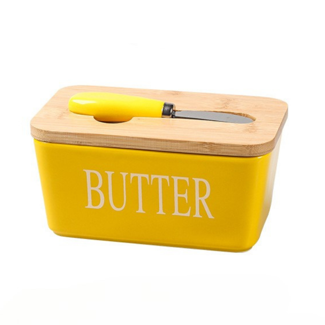 Yellow ceramic butter dish with bamboo lid and spreader, text "BUTTER" printed.