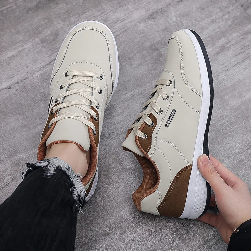 Beige and brown sneaker on foot on tan wood floor