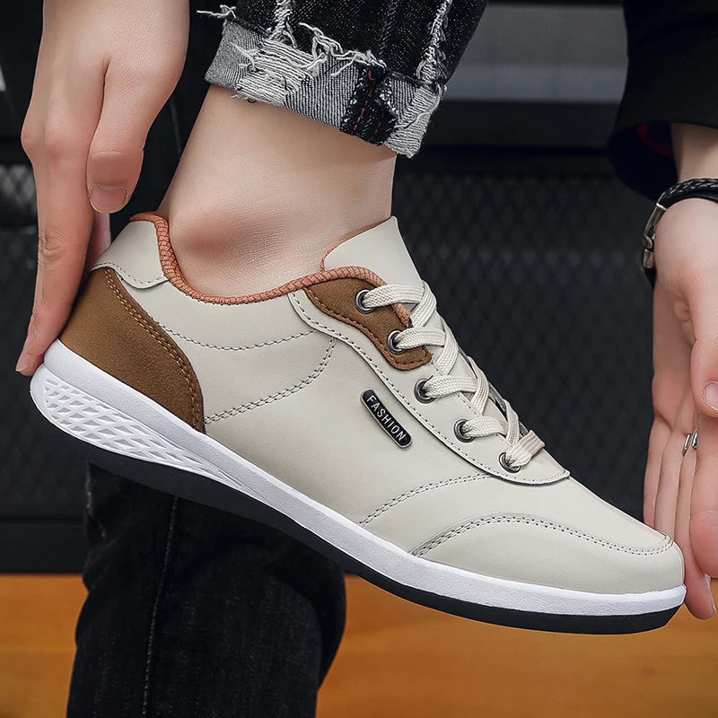 Beige and brown sneakers, hand-held close-up display, side view