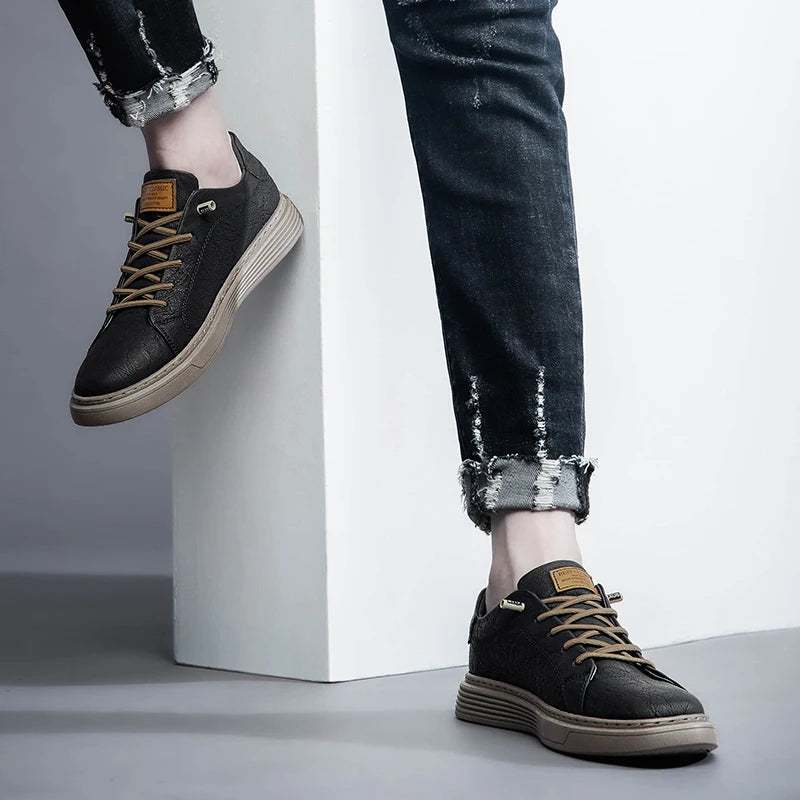 Black oxford sneakers styled with frayed jeans, one foot against wall pose