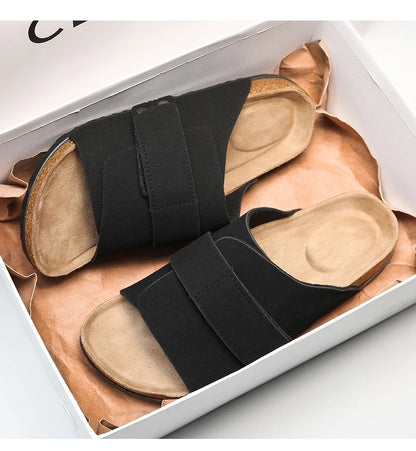 Black suede men's sandals with cushioned footbed in shoebox, top-down view


