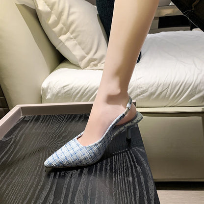 Black tweed slingback heels worn indoors with skirt outfit