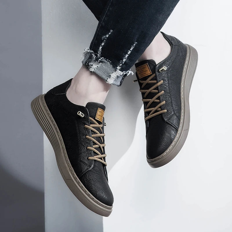 Both feet wearing black leather sneakers, front angle with neutral background