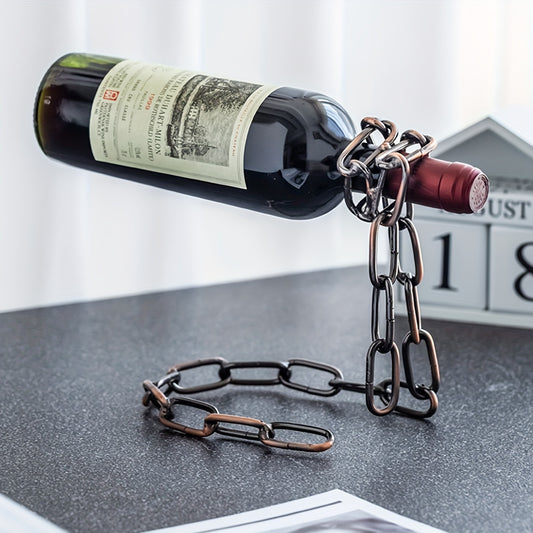 Bronze chain wine holder suspending a red wine bottle on a black table with calendar background