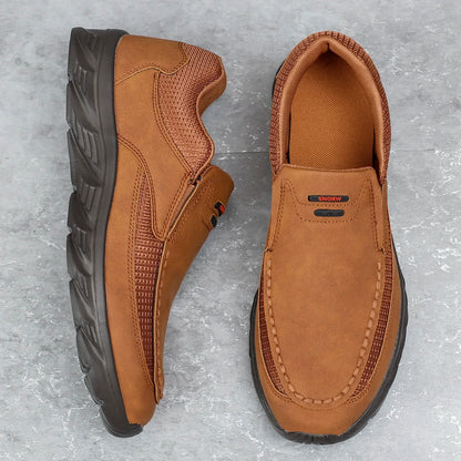 Brown leather casual shoes with mesh detail, flat lay view on grey background