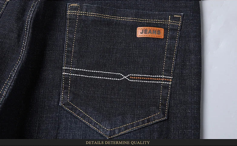Close-up of back pocket stitching and leather patch on black denim jeans