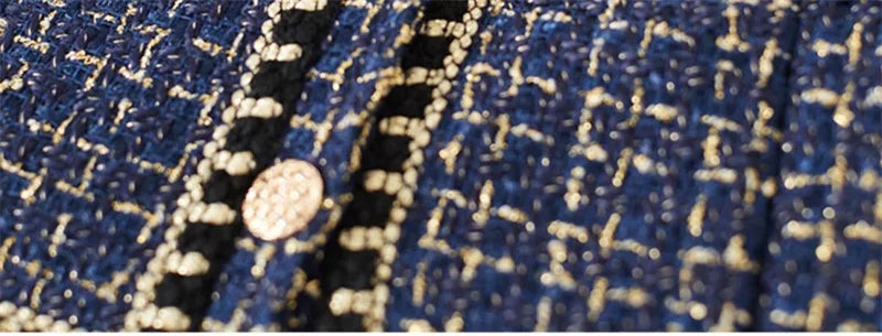 Close-up of tweed fabric texture with metallic thread and gold trim