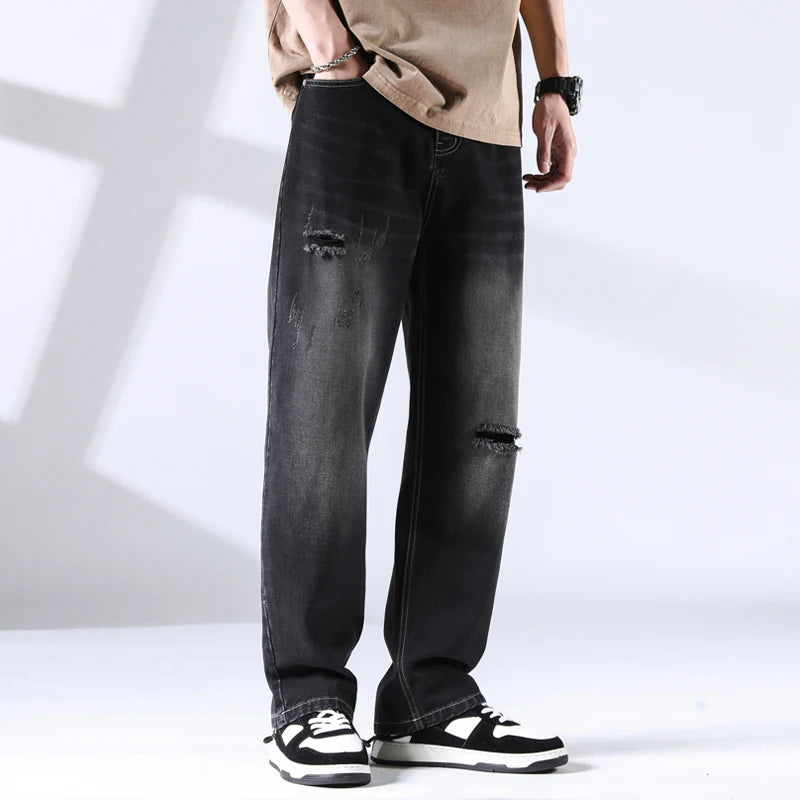 Faded light wash ripped jeans with knee tear and backpack prop, front angle