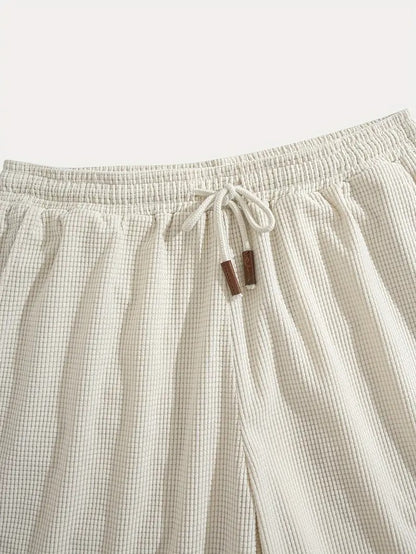 Flat lay of cream textured drawstring casual shorts, close-up of label tag