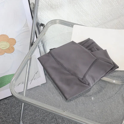 Folded dark gray yoga leggings on chair