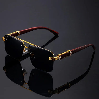 Frameless sunglasses with blue gradient lenses and gold temples on black reflective background