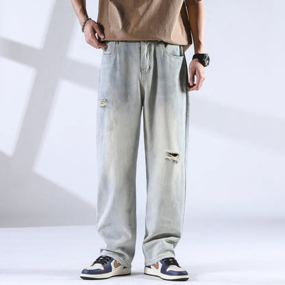 Frost-faded denim jeans with rips, front view under soft lighting