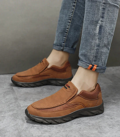 Full-body side view of man wearing brown leather casual shoes on tiled floor
