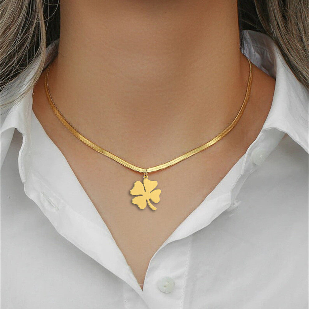 Gold clover cross pendant necklace on model, white outfit, close-up front view
