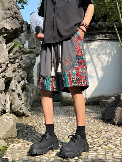 Gray ethnic patchwork shorts with tassel drawstring, styled with black shirt and chunky shoes
