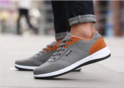 Grey and orange sneakers with light blue jeans in walking motion