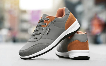Grey and orange walking sneaker shown raised with heel detail