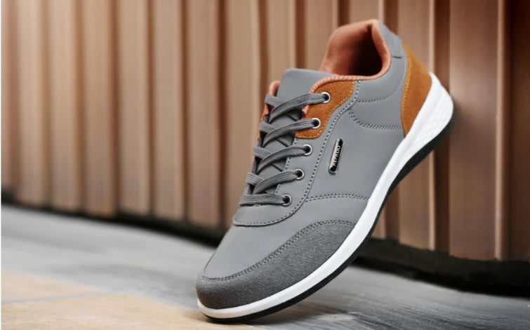 Grey and orange walking sneaker shown raised with heel detail