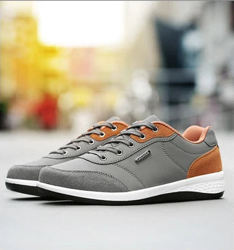 Grey and orange walking sneaker shown raised with heel detail, side view