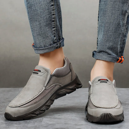 Grey leather casual loafers with mesh panels, worn with cuffed denim