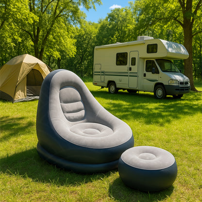 Inflatable lounge chair and footrest set up at a green campsite with tent and RV