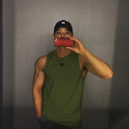 Man in army green quick-dry mesh tank top for workouts, athletic front pose in mirror