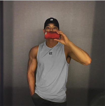 Man in gray quick-dry mesh tank top for workouts, athletic front pose in mirror