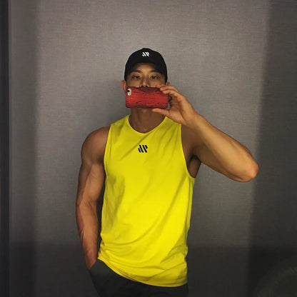 Man in yellow quick-dry mesh tank top for workouts, athletic front pose in mirror