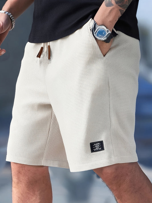 Man wearing cream textured drawstring casual shorts, front view