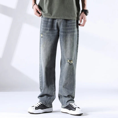 Men wearing stone blue straight leg jeans with ripped knee, light fade wash, front view