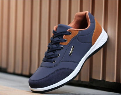 Navy and orange sneakers on feet walking with cuffed denim