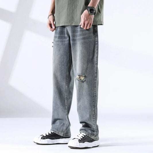 Stone blue straight leg jeans with ripped knee, light fade wash, front view