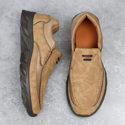 Tan leather loafers on the ground, showcasing soft upper and rugged sole