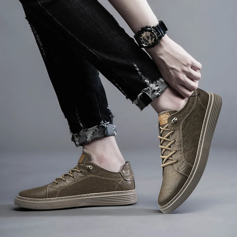 Taupe brown leather sneakers styled casually with wristwatch and frayed jeans