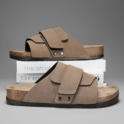 Taupe suede strap sandals for men stacked on white books, soft cork insole visible